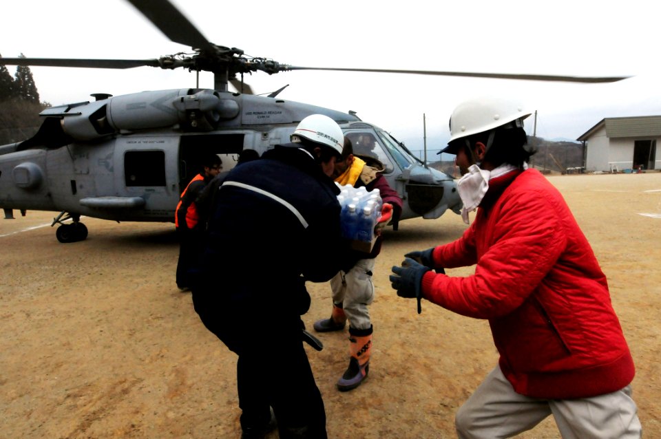 US Navy 110315-N-5503T-461 Japanese citizens move food and water out of an HH-60H Sea Hawk helicopter assigned to the Black Knights of Helicopter A