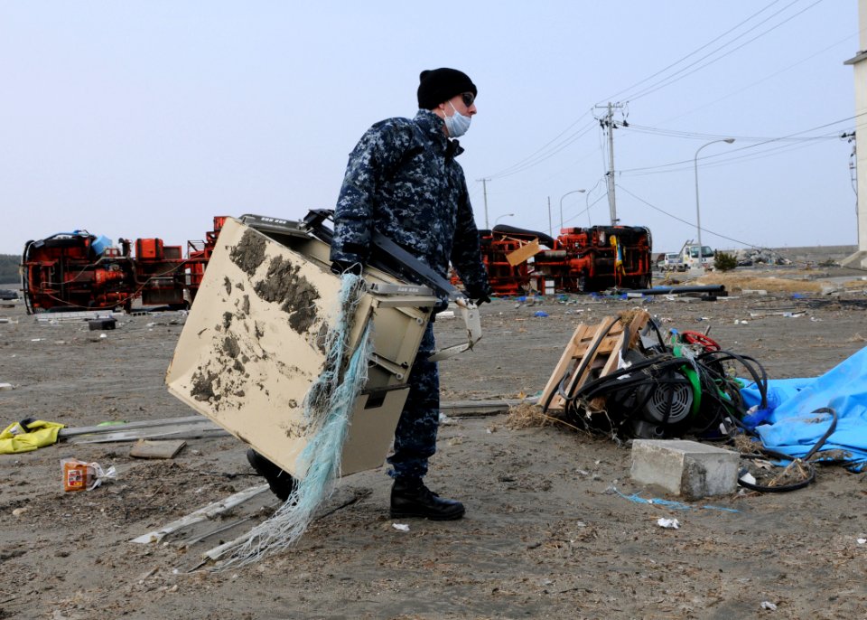 US Navy 110314-N-MU720-001 Personnel Specialist Seaman Ricardo Longoria, from Edinburg, Texas, assigned to Naval Air Facility Misawa, removes debri