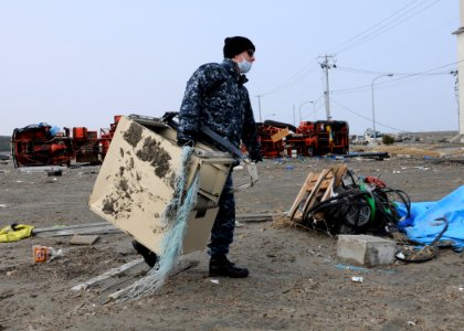 US Navy 110314-N-MU720-001 Personnel Specialist Seaman Ricardo Longoria, from Edinburg, Texas, assigned to Naval Air Facility Misawa, removes debri