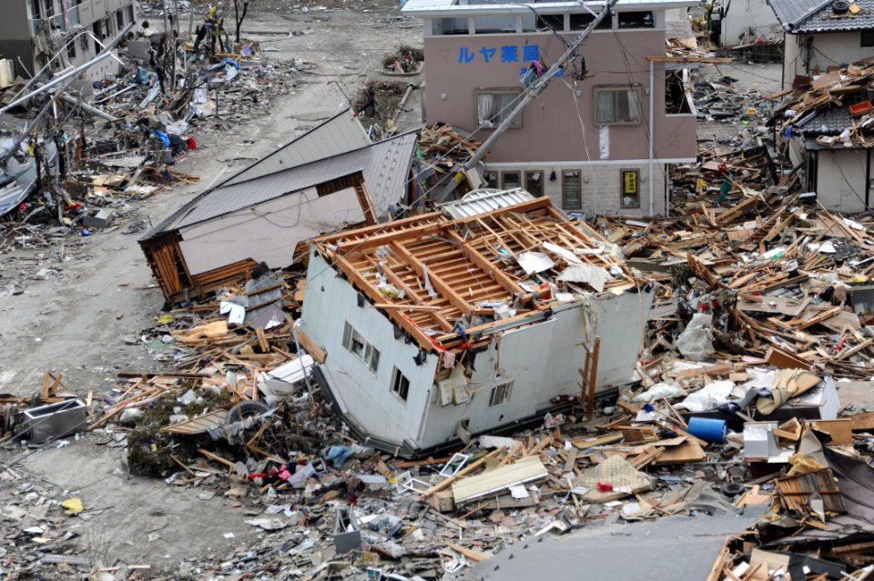 US Navy 110315-N-2653B-107 An upended house is among debris in Ofunato, Japan, following a 9.0 magnitude earthquake and subsequent tsunami
