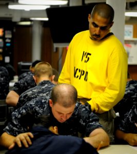 US Navy 110317-N-8040H-037 Chief Aviation Boatswain's Mate (Handling) Michael Dominguez supervises the E-4 advancement exam aboard the Nimitz-class