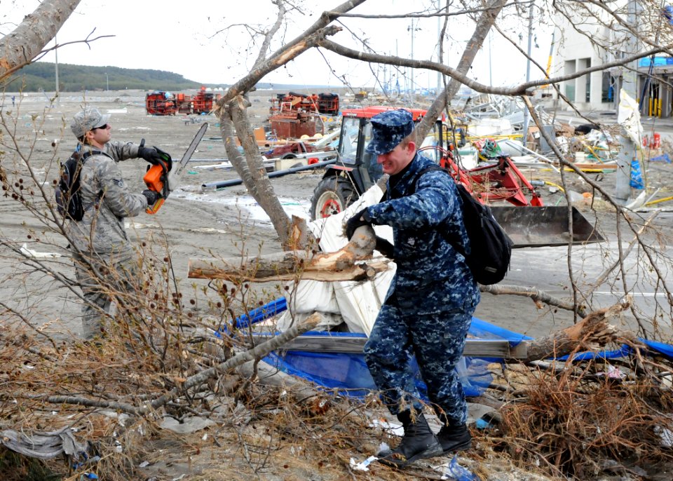 US Navy 110315-N-MU720-088 Service members clear downed trees from a park at the Misawa Fishing Port