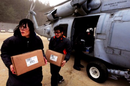 US Navy 110315-N-5503T-428 Japanese citizens move food and water out of an HH-60H Sea Hawk helicopter assigned to the Black Knights of Helicopter A