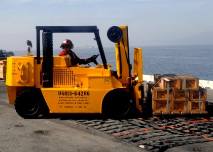 US Navy 110316-N-3729D-202 A Sailor places a pallet of ammunition onto a cargo net aboard the amphibious assault ship USS Peleliu (LHA 5)