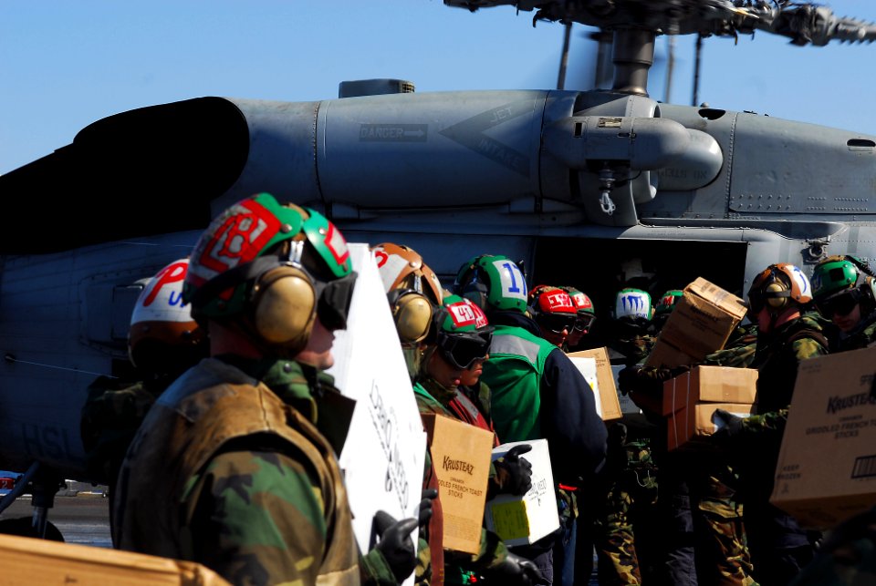 US Navy 110318-N-GL340-053 Sailors load food and humanitarian supplies aboard an HH-60H Sea Hawk helicopter assigned to the Black Knights of Helico