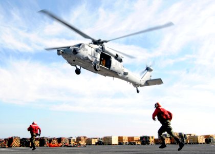 US Navy 110316-N-3729D-280 Sailors run to attach a pole pendant to an MH-60S Sea Hawk helicopter aboard the amphibious assault ship USS Peleliu (LH