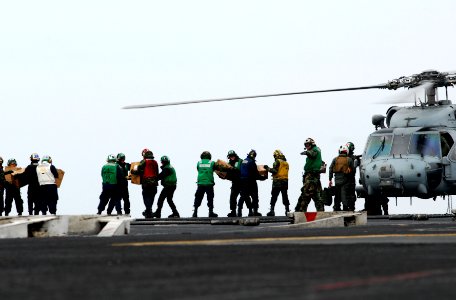 US Navy 110315-N-GL340-170 Sailors move food and water onto an HH-60H Sea Hawk helicopter assigned to the Black Knights of Anti-Submarine Squadron