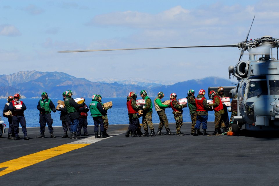 US Navy 110318-N-GL340-013 Sailors load food and humanitarian supplies aboard an HH-60H Sea Hawk helicopter assigned to the Black Knights of Helico