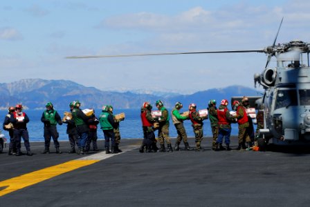 US Navy 110318-N-GL340-013 Sailors load food and humanitarian supplies aboard an HH-60H Sea Hawk helicopter assigned to the Black Knights of Helico
