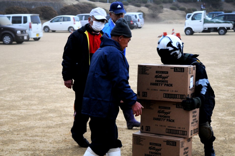 US Navy 110315-N-IC111-652 Naval Air Crewman 2nd Class Zack DelCorte stacks boxes of food for Japanese citizens