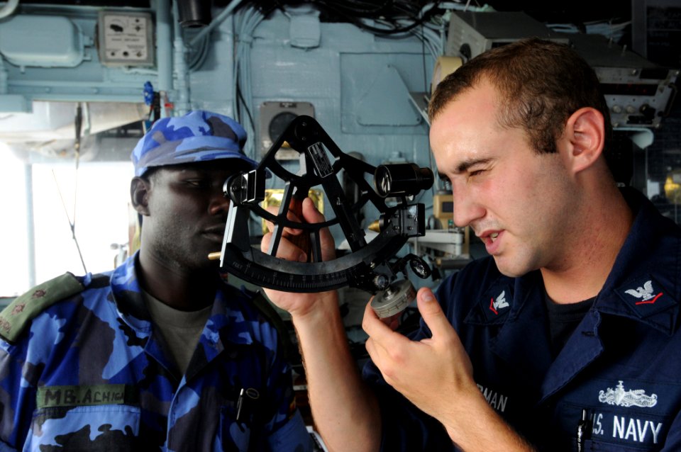 US Navy 110316-N-5085J-019 Quartermaster 3rd Class Josef Zimmerman demonstrates solar navigation using a sextant for Ugandan navy Lt. Mathew Achiga
