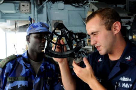 US Navy 110316-N-5085J-019 Quartermaster 3rd Class Josef Zimmerman demonstrates solar navigation using a sextant for Ugandan navy Lt. Mathew Achiga