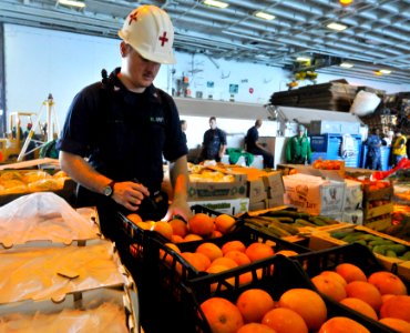 US Navy 110318-N-3852A-882 Hospital Corpsman 3rd Class Cody M. Stafford inspects produce in the hangar bay aboard USS Enterprise (CVN 65)
