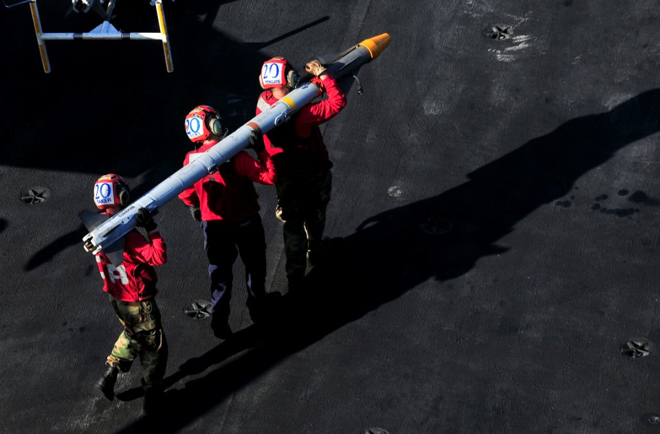 US Navy 110321-N-0074G-001 Aviation ordnancemen assigned to the aircraft carrier USS Enterprise (CVN 65) carry an aerial intercept missile (AIM) fr