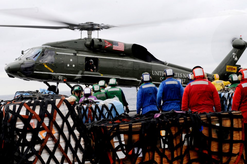 US Navy 110321-N-3005P-396 Sailors watch as an SH-60F Sea Hawk helicopter lifts off from the fight deck of the U.S. 7th Fleet command ship USS Blue