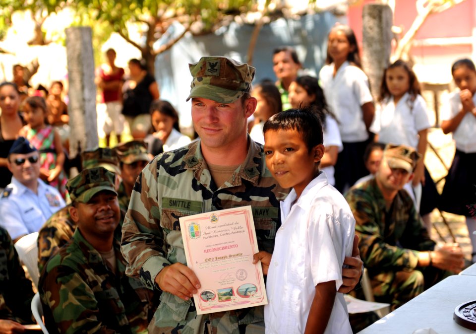 US Navy 110318-N-EC642-219 Equipment Operator 2nd Class Joseph Smittle receives a certificate of appreciation from a student at Escuela Rural Lempi