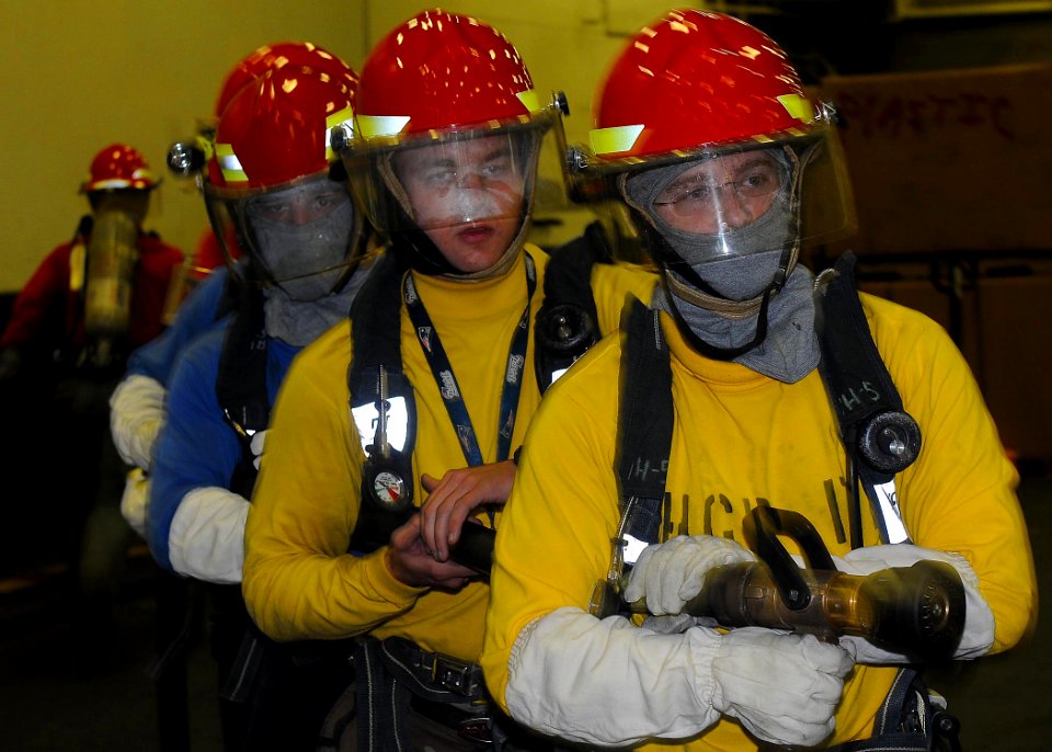 US Navy 110317-N-2908M-003 Aviation Boatswain's Mate (Handling) 2nd Class David Sweaza leads a hose team during fire fighting training aboard the a