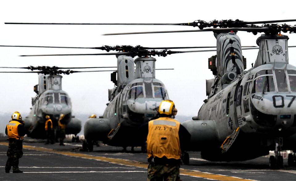 US Navy 110321-N-4743B-309 CH-46E Sea Knight helicopters aboard the forward-deployed amphibious assault ship USS Essex (LHD 2) prepare to deliver h