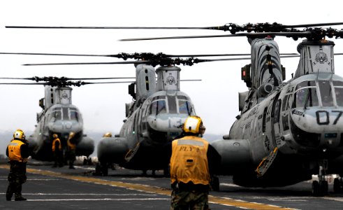 US Navy 110321-N-4743B-309 CH-46E Sea Knight helicopters aboard the forward-deployed amphibious assault ship USS Essex (LHD 2) prepare to deliver h