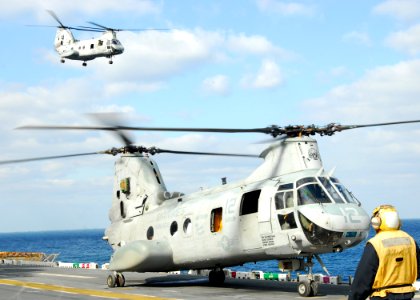 US Navy 110318-N-8607R-130 A CH-46E Sea Knight helicopter takes off from the flight deck of the forward-deployed amphibious assault ship USS Essex