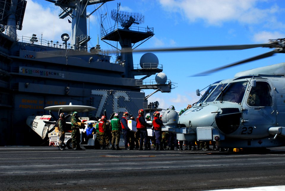 US Navy 110318-N-GL340-043 ailors load food and humanitarian supplies aboard an HH-60H Sea Hawk helicopter assigned to the Black Knights of Helicop