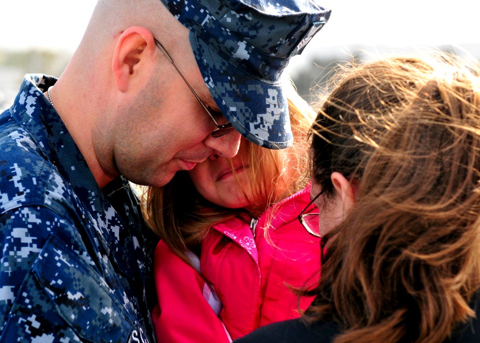 US Navy 110321-N-BT887-039 Hospital Corpsman 1st Class Edward Schulz embraces his family before deploying aboard the amphibious transport dock ship