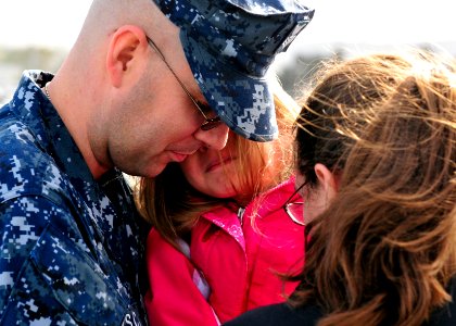 US Navy 110321-N-BT887-039 Hospital Corpsman 1st Class Edward Schulz embraces his family before deploying aboard the amphibious transport dock ship