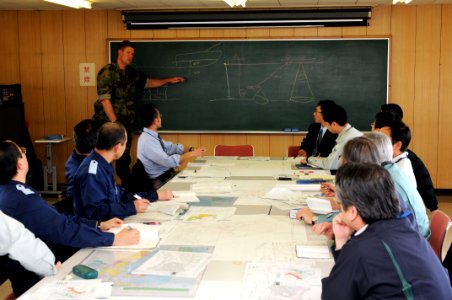 US Navy 110318-N-MU720-127 Lt. Cmdr. Derek Peterson, from Cocoa, Fla., a U.S. 7th Fleet salvage officer, draws a diagram for Hachinohe officials de