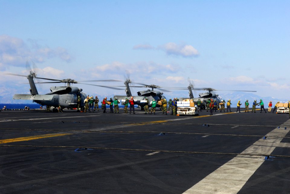 US Navy 110318-N-SB672-084 Sailors and Marines aboard the aircraft carrier USS Ronald Reagan (CVN 76)load humanitarian assistance supplies onto HH