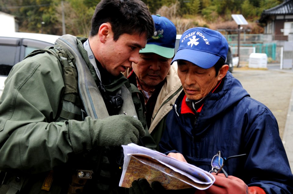 US Navy 110321-N-IC111-213 Lt. j.g. Jaden Risner speaks with Japanese citizens during a humanitarian assistance mission