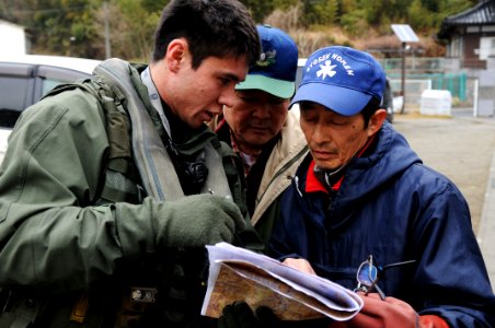 US Navy 110321-N-IC111-213 Lt. j.g. Jaden Risner speaks with Japanese citizens during a humanitarian assistance mission