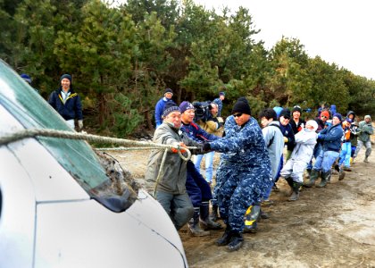 US Navy 110319-N-2653B-047 Service members and Misawa residents pull a damaged vehicle from the woods near the Misawa port