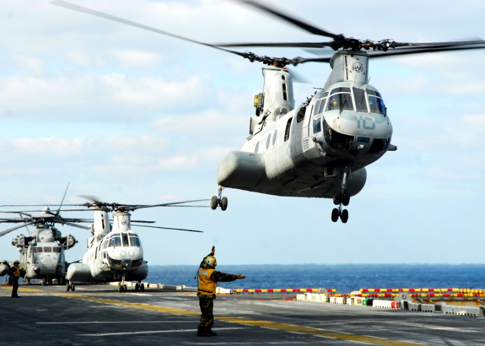US Navy 110318-N-8607R-121 A CH-46E Sea Knight helicopter takes off from the flight deck of the forward-deployed amphibious assault ship USS Essex