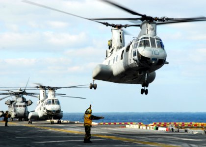 US Navy 110318-N-8607R-121 A CH-46E Sea Knight helicopter takes off from the flight deck of the forward-deployed amphibious assault ship USS Essex