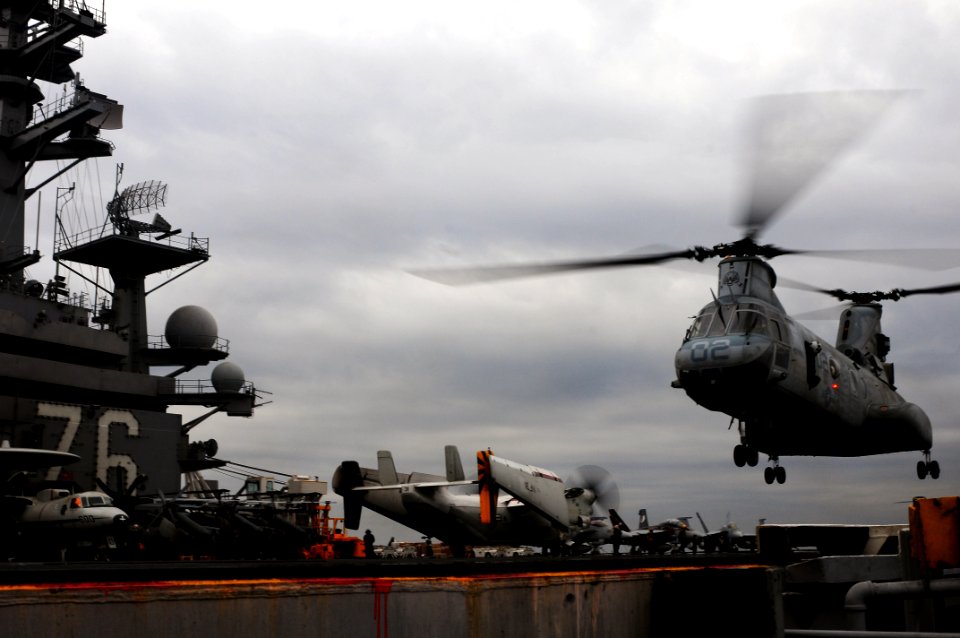 US Navy 110321-N-5503T-301 A CH-46E Sea Knight helicopter lifts off the flight deck of the aircraft carrier USS Ronald Reagan (CVN 76)