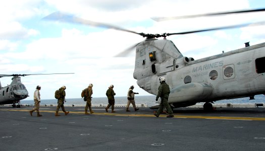US Navy 110318-N-8607R-055 Marines board a CH-46E Sea Knight helicopter aboard the forward-deployed amphibious assault ship USS Essex (LHD 2) photo