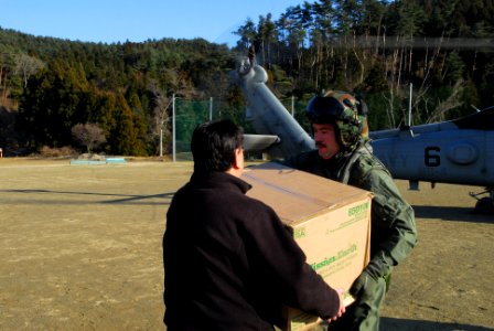 US Navy 110318-N-SB672-918 Lt. Cmdr. Don Short delivers toilet-paper to a Japanese man at a shelter photo