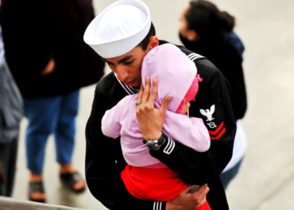 US Navy 110321-N-BT887-167 Operations Specialist 2nd Class Steven Mayorga embraces his daughter before deploying aboard the amphibious transport do