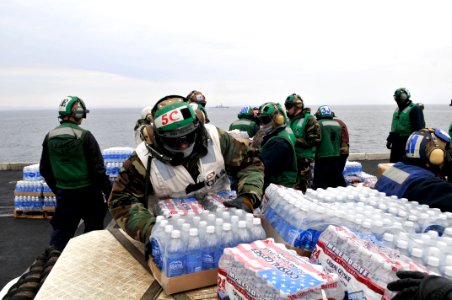 US Navy 110319-N-DM338-030 Sailors and Marines load food and humanitarian supplies on the flight deck of the aircraft carrier USS Ronald Reagan (CV
