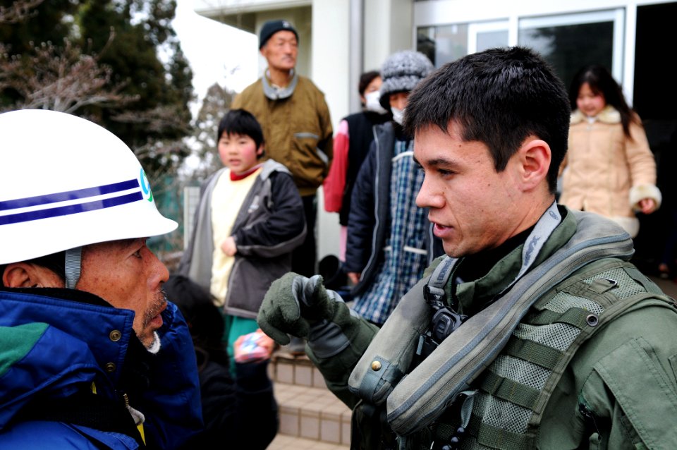 US Navy 110321-N-IC111-117 Lt. j.g. Jaden Risner speaks with Japanese citizens during a humanitarian assistance mission