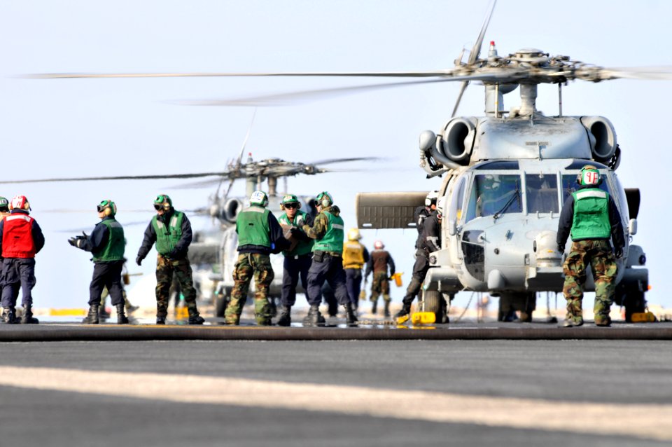 US Navy 110322-N-DM338-120 Sailors and Marines load food and humanitarian assistance supplies onto an SH-60B Sea Hawk helicopter