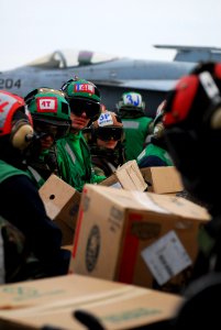 US Navy 110322-N-SB672-016 Sailors and Marines aboard the aircraft carrier USS Ronald Reagan (CVN 76) load humanitarian assistance supplies onto an
