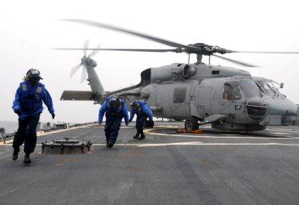 US Navy 110320-N-8288P-304 Sailors aboard USS Fitzgerald (DDG 62) run away from an SH-60 Sea Hawk helicopter after applying landing chocks during f