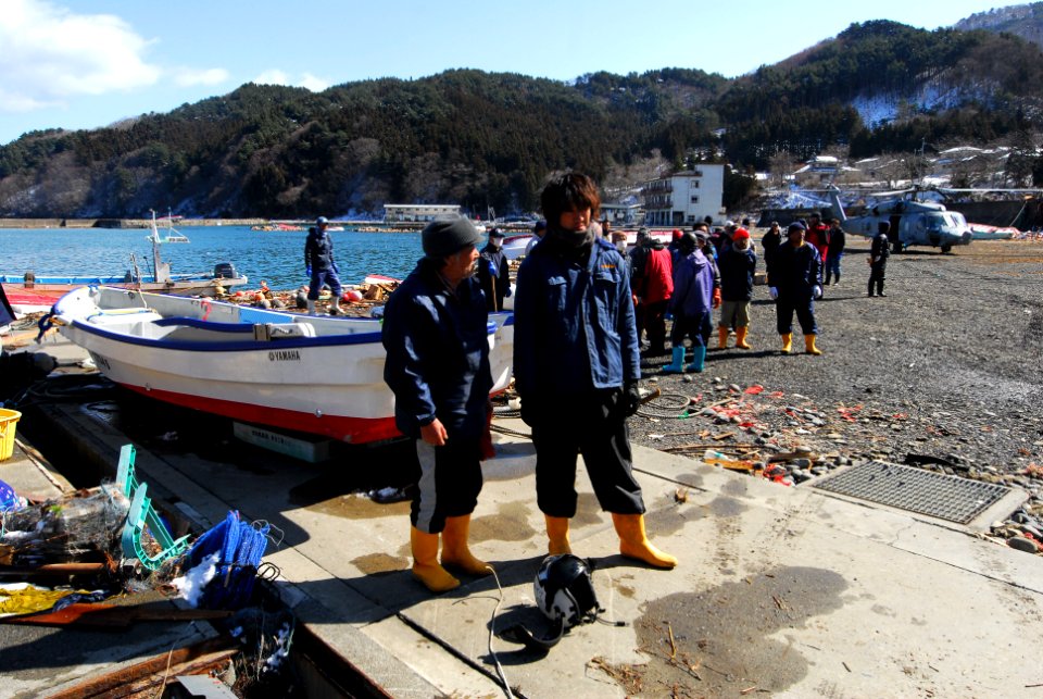 US Navy 110318-N-SB672-539 Japanese men stand near their boat in a fishing village affected by a 9.0-magnitude earthquake and subsequent tsunami