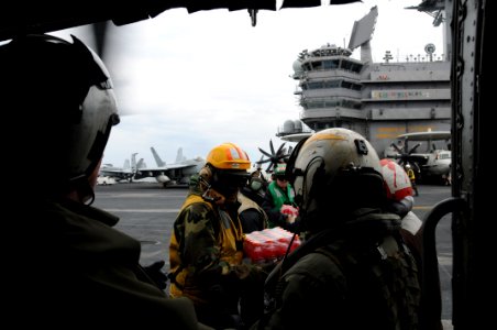 US Navy 110321-N-2653B-062 Sailors aboard the aircraft carrier USS Ronald Reagan (CVN 76) load supplies onto an SH-60F Sea Hawk helicopter from the