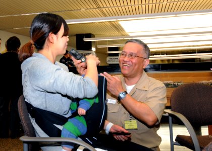 US Navy 110323-N-AE328-006 Cmdr. Manuel Biadog, Jr., Naval Base Kitsap command chaplain, helps a military spouse contact local family members after