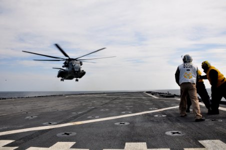 US Navy 110319-N-3999C-883 Chief Warrant Officer David Metham helps Boatswain's Mate 2nd Class Carlos Gonzales hold Seaman John O'Brien as he guide