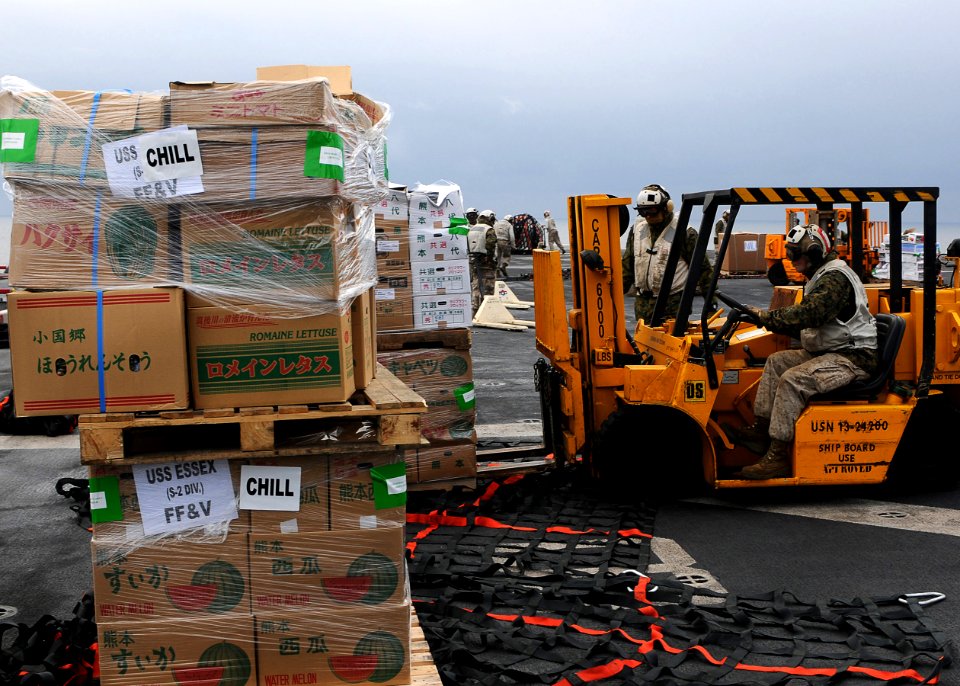 US Navy 110321-N-4743B-114 Marines load pallets of supplies on the flight deck of the forward-deployed amphibious assault ship USS Essex (LHD 2) du