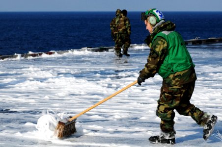 US Navy 110323-N-IC111-533 Aviation Electronics Technician Airman Ryan Cordova, from Albuquerque, N. M., scrubs the flight deck after a countermeas