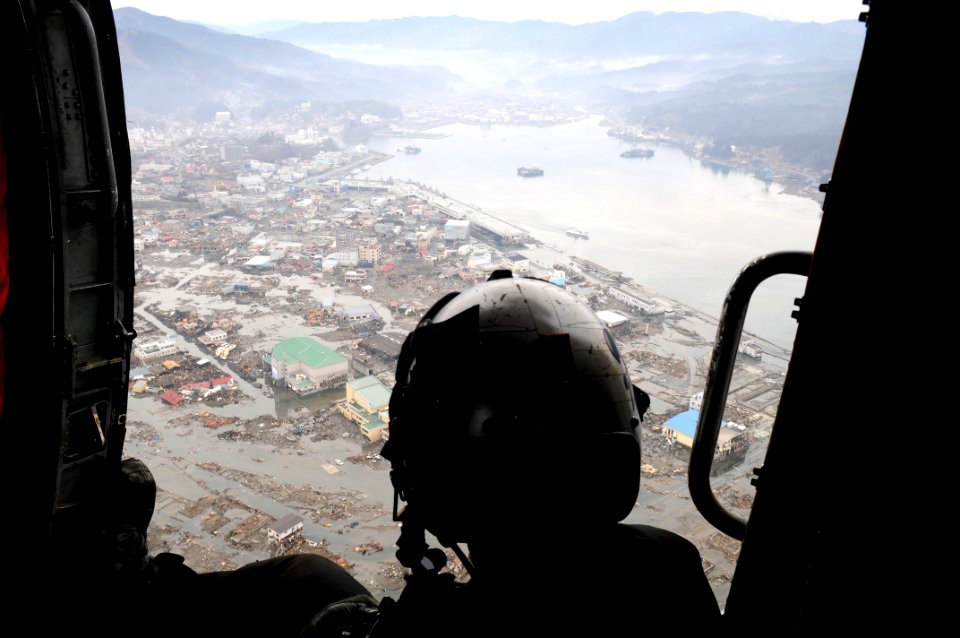US Navy 110321-N-IC111-043 Naval Air Crewman 2nd Class Justin Dowd, from Phoenix, surveys areas affected by a tsunami caused by a 9.0 magnitude ear